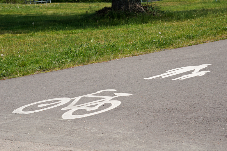 En asfalterad väg med symboler på vägen av en cykel och en person som går